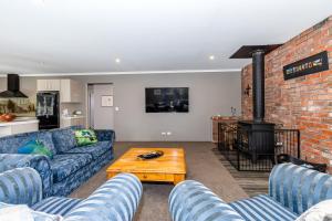 a living room with a couch and a brick wall at Contemporary Methven Abode in Methven