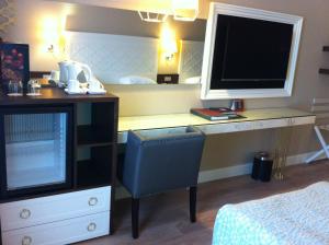 a bedroom with a desk with a television and a bed at Fame Residence Kemer & Spa in Kemer