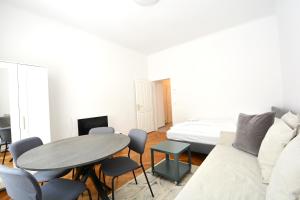 ein Wohnzimmer mit einem Tisch und einem Sofa in der Unterkunft UNIVERSUM APARTMENT 4 in Wien
