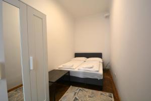 Un pequeño dormitorio con una cama en la esquina en UNIVERSUM APARTMENT 4, en Viena