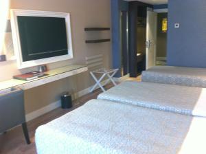 a hotel room with two beds and a television at Fame Residence Kemer & Spa in Kemer