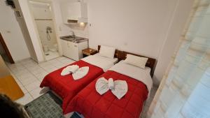 a bedroom with two beds with white bows on them at Kapolos budget hotel in Loutra Edipsou