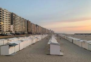 a row of beach huts on a sandy beach at Appartement Wim in Blankenberge