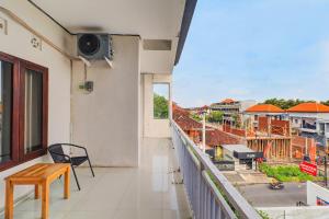 a balcony with a table and a view of a city at OYO 92315 Prostay Bali in Denpasar