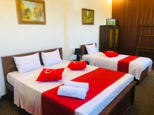 2 Betten in einem Hotelzimmer mit roter und weißer Bettwäsche in der Unterkunft Cannel view apartment Negombo in Negombo