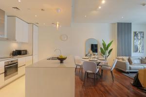 a kitchen and living room with a table and chairs at HiGuests - Charming Retreat in CityWalk With Balcony and Pool in Dubai