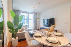 een woonkamer met een eettafel en een woonkamer bij HiGuests - Charming Retreat in CityWalk With Balcony and Pool in Dubai