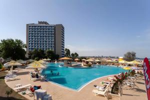 una gran piscina con sillas y un hotel en Hotel AquaPark Balada Saturn - ULTRA ALL INCLUSIVE en Mangalia