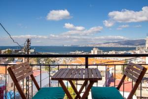 balcón con mesa de madera y 2 sillas en Lovely House with Sea View and Backyard en İzmir