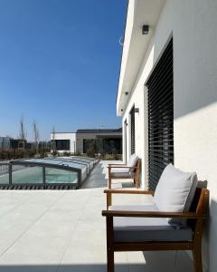 un patio con 2 sillas y una piscina en Golf Villa Stella s bazénom, en Šajdíkove Humence