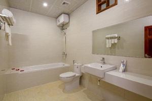 La salle de bains blanche est pourvue de toilettes et d'un lavabo. dans l'établissement Khách sạn Phạm Gia Đà Nẵng (Phạm Gia Hotel), à Đà Nẵng
