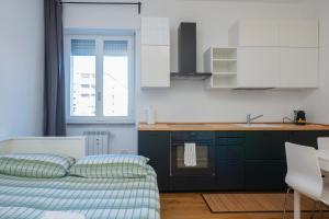 1 dormitorio con 1 cama y cocina en I Host Apartment - Fiuggi 59, en Milán