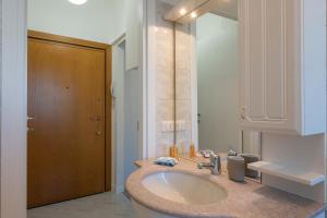 baño con lavabo y espejo grande en I Host Apartment - Fiuggi 59, en Milán