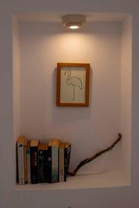 een plank met boeken en een foto aan de muur bij Sea view Villa in Koutsounari