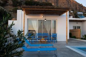 a patio with blue chairs next to a house at Sea view Villa in Koutsounari