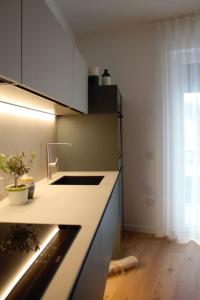 a kitchen with white counters and a sink and a window at Al civico 50 in Andria