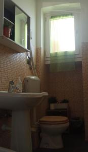 Un baño con lavabo, inodoro y espejo. en BB Torino Chicca Stadio Olimpico, en Turín