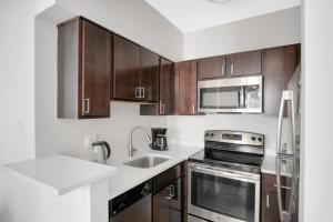 a kitchen with wooden cabinets and stainless steel appliances at Gold Coast 2BR w Gym Roof nr Mag Mile CHI-626 in Chicago