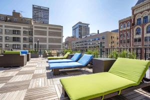 a rooftop patio with blue and green chairs and buildings at Gold Coast 2BR w Gym Roof nr Mag Mile CHI-626 in Chicago