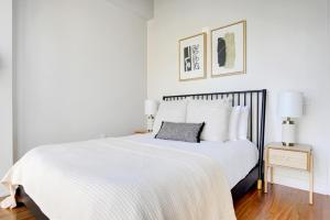 a white bedroom with a white bed and two lamps at River N 1BR w Gym Pool WD nr Mag Mile CHI-440 in Chicago