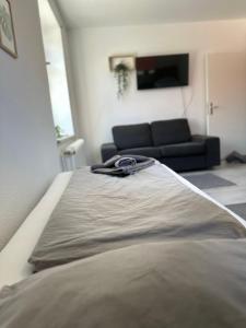 um quarto com uma cama e um sofá num quarto em Green Park Apartment em Bremerhaven