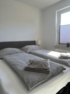 uma cama com uma toalha em cima em Green Park Apartment em Bremerhaven