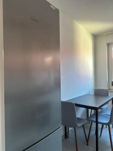 uma cozinha com uma mesa e uma mesa e cadeiras em Green Park Apartment em Bremerhaven