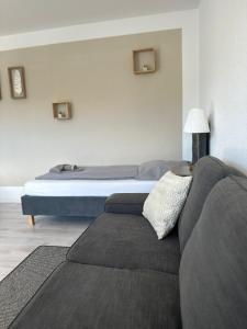 uma sala de estar com um sofá e uma cama em Green Park Apartment em Bremerhaven