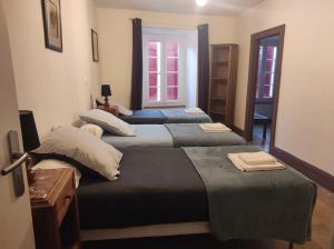 a group of three beds in a room at Hôtel Restaurant des Voyageurs in Nant