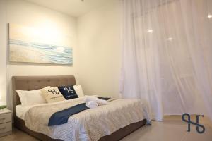 a bedroom with a bed and a window at Homesuite' Home at The Shore in Kota Kinabalu
