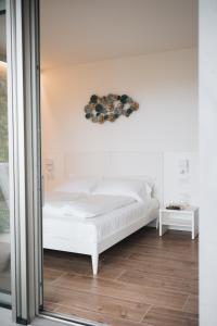 a white bed in a room with a mirror at Sea Breeze in Caorle +67 photos