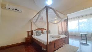 ein Schlafzimmer mit einem Himmelbett mit Baldachin in der Unterkunft Ary Beachfront Homestay Nyali- On Mombasa Beach in Mombasa