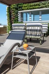 - deux chaises et une table sur une terrasse avec une orange dans l'établissement Sea Breeze, à Caorle