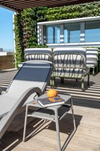 two chairs and a table on a patio with an orange on it at Sea Breeze in Caorle