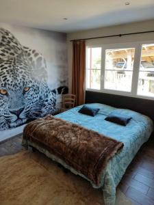 a bedroom with a bed with a leopard mural on the wall at Modern house with Pool & Jacuzzi in Carcans in Carcans