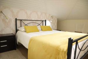 sypialnia z dużym łóżkiem z 2 żółtymi poduszkami w obiekcie Eyes in the Sky w Funchal