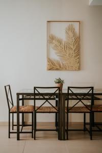 uma mesa de jantar com duas cadeiras e uma foto em Apartamentos Poniente - Mares em Torre del Mar