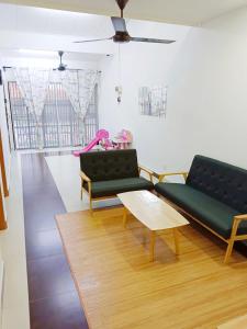 a living room with two green couches and a coffee table at The Loft Bentong in Bentong