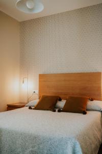 トレ・デル・マールにあるApartamentos Poniente - Maresのベッドルーム1室(大型ベッド1台、木製ヘッドボード付)