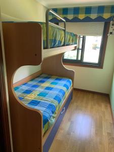 Etagenbett in einem Zimmer mit Fenster in der Unterkunft APARTAMENTO LADEIRA PLAYA in Baiona