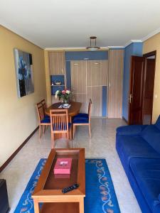 een woonkamer met een tafel en een blauwe bank bij APARTAMENTO LADEIRA PLAYA in Baiona