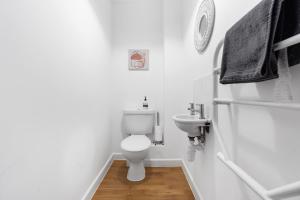 ein weißes Bad mit einem WC und einem Waschbecken in der Unterkunft House 5 Ironcroft - Modern Pet-friendly & hot tub, Walk to beach & village in Porthtowan