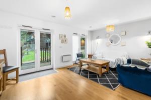 ein Wohnzimmer mit einem Sofa und einem Tisch in der Unterkunft House 5 Ironcroft - Modern Pet-friendly & hot tub, Walk to beach & village in Porthtowan