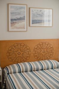 a bed with two pictures on top of it at Rolli Dream in Genova +42 photos