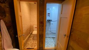 La salle de bains est pourvue de toilettes et d'une porte ouverte. dans l'établissement Дом с оленями, à Gyumri