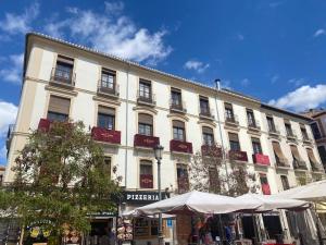 un gran edificio blanco con muchas ventanas en BiBo Suites Plaza Nueva, en Granada