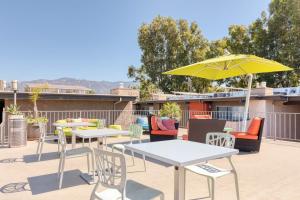 a patio with tables and chairs and a yellow umbrella at Pasadena 2BR w Gym Pool nr Colorado Ave LAX-863 in Pasadena