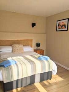 a bedroom with a bed with a striped blanket at Kingfisher Barn B&B in Abingdon