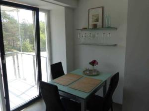ein Esszimmer mit einem Tisch mit Stühlen und einem Fenster in der Unterkunft Strandresidenz Appartement Haubentaucher G22 in Binz