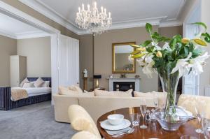 a living room with a couch and a table with flowers at Elizabeth House Flat 2 in Cheltenham
